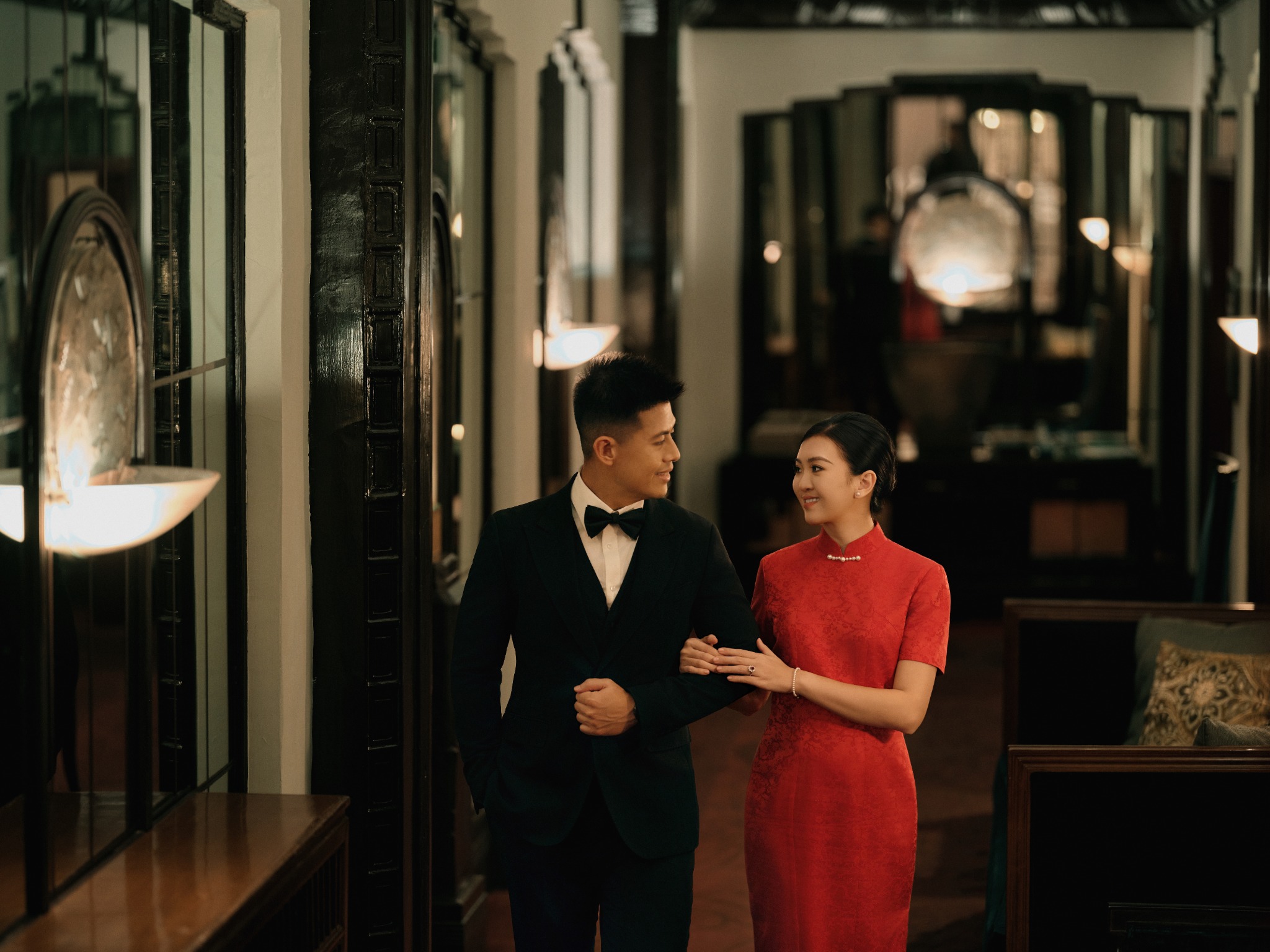 Patrick and Ivy walking together through a softly lit hallway